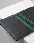 Green and black leather wallet on a white surface