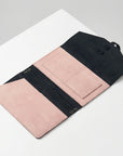 Pink and black wallet on a white surface
