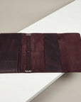 Brown leather folder on a white surface with a beige background