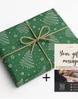 Green gift wrap with white patterns and a brown ribbon, accompanied by a gift message card on a white background.