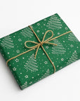 Green gift box with white tree pattern and string bow on a white background