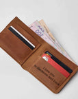 A brown leather bifold wallet shown open on a light gray background, filled with cards and cash. The inside front pocket has the printed phrase 'I love you to the moon and back' in black text.
