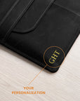 Close-up of a black leather folio or laptop sleeve on a light wood surface, with an orange callout pointing to the corner where the letters 'GHT' are personalized, and text reading 'YOUR PERSONALIZATION'.