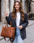 Woman holding a brown leather bag on a street