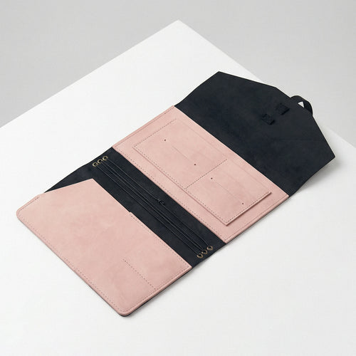 Pink and black wallet on a white surface