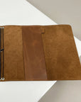 Brown leather wallet on a white surface with a beige background