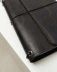 Black leather wallet on a white surface