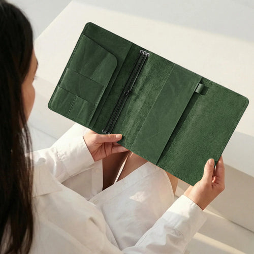 Person holding a green wallet with a neutral background