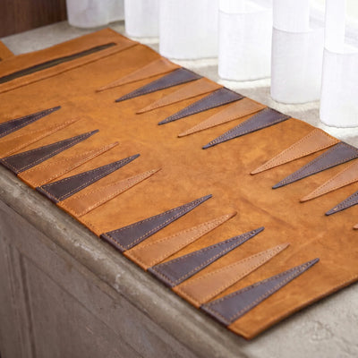 Brown leather placemat with geometric pattern on a stone surface