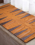 Brown leather placemat with geometric pattern on a stone surface