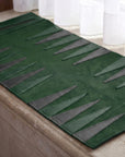 Green and gray textured rug on a wooden floor