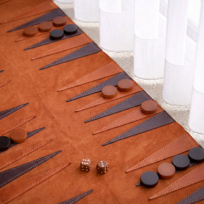 Backgammon board with pieces and dice on a carpeted floor.