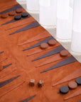 Backgammon board with pieces and dice on a carpeted floor.