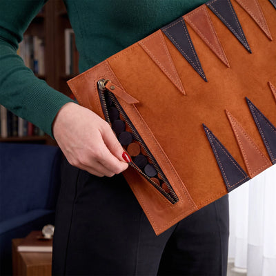 Person holding a brown leather clutch with geometric patterns