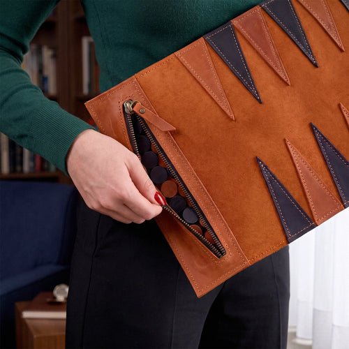 Person holding a brown leather clutch with geometric patterns