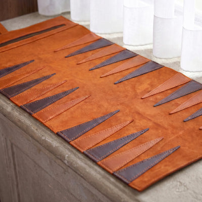 Brown leather placemat with geometric pattern on a table.