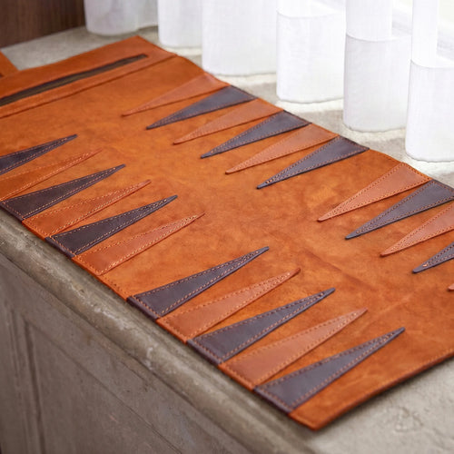 Brown leather placemat with geometric pattern on a table.
