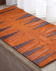 Brown leather placemat with geometric pattern on a table.