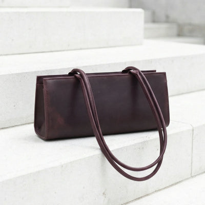 Brown leather handbag on a white marble staircase