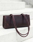 Brown leather handbag on a white marble staircase