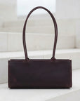 Brown leather handbag on a light background