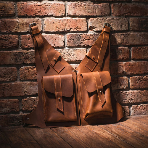 Two brown leather bags against a brick wall.