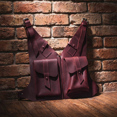 Two leather bags against a brick wall