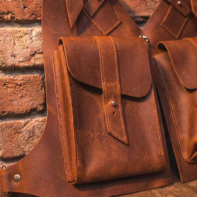 Brown leather pouches against a brick wall background