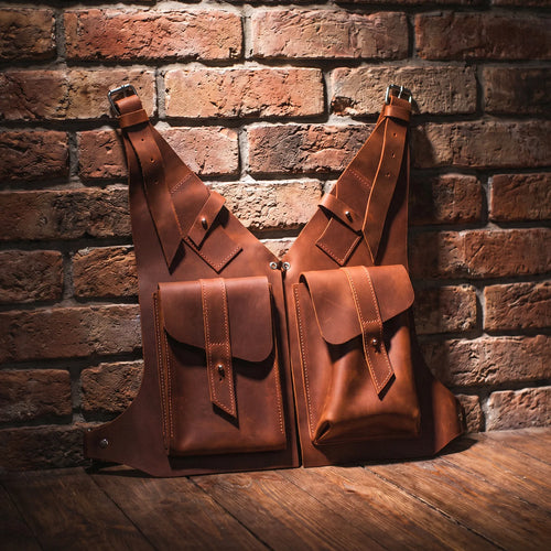 Two brown leather bags against a brick wall.