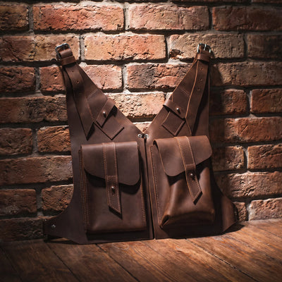 Two brown leather bags against a brick wall.