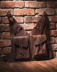 Two brown leather bags against a brick wall.